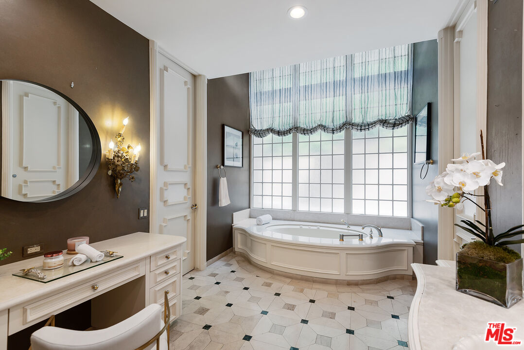 1018 Summit Drive Beverly Hills, CA 90210 - Photo 17 of 21 a bathroom with a bathtub sink and mirror