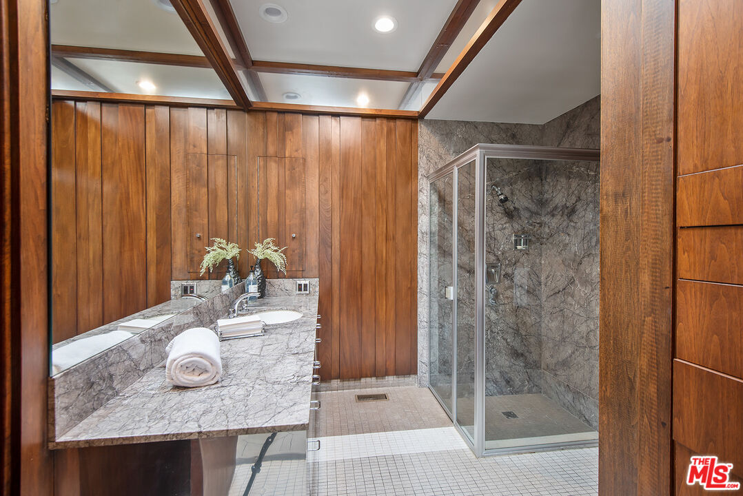 1018 Summit Drive Beverly Hills, CA 90210 - Photo 18 of 21 a bathroom with a granite countertop shower and a sink