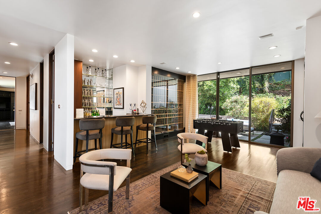 1018 Summit Drive Beverly Hills, CA 90210 - Photo 8 of 21 a living room with furniture and a large window