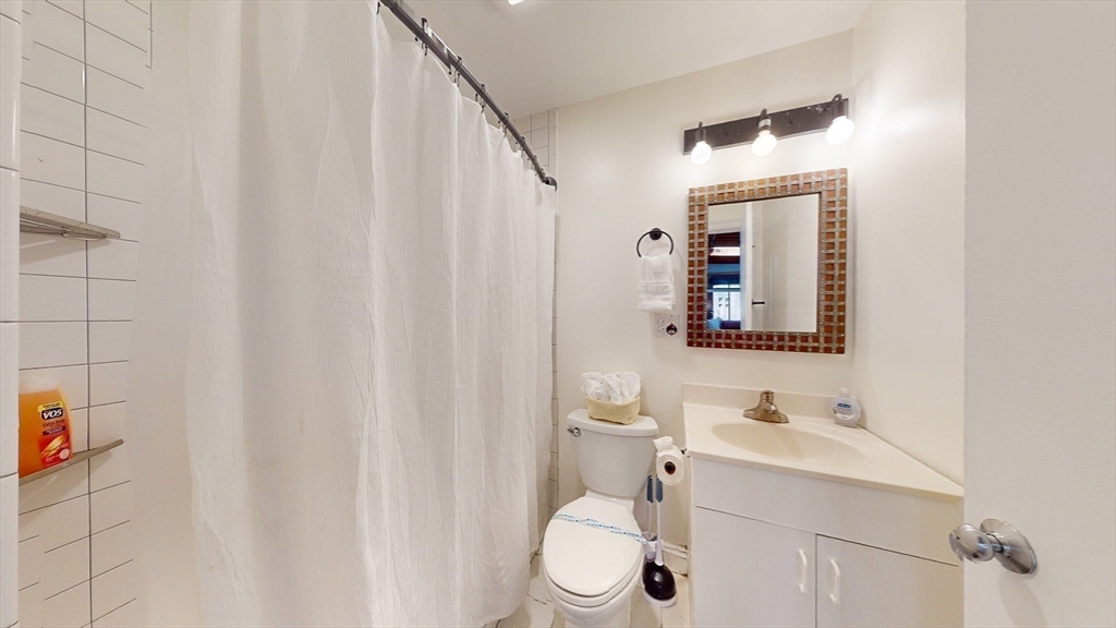 19 Stanhope Street, Unit 3A Boston, MA 02116 - Photo 19 of 19 a bathroom with a sink a toilet and shower curtain