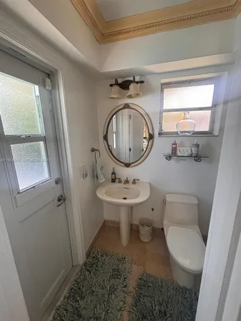a bathroom with a sink toilet and a mirror