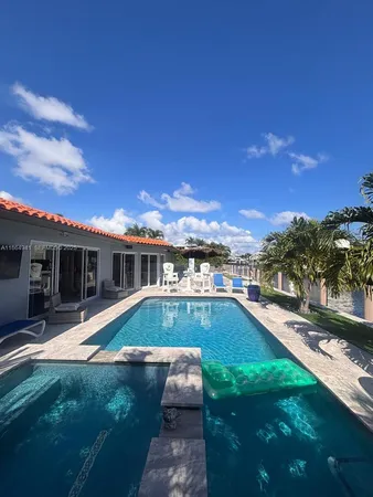 a view of a house with swimming pool and a yard