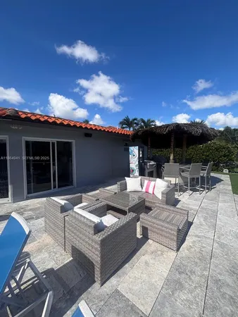 a view of a patio with couches and table and chairs and potted plants