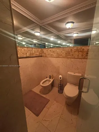 a bathroom with a sink a toilet a mirror and shower