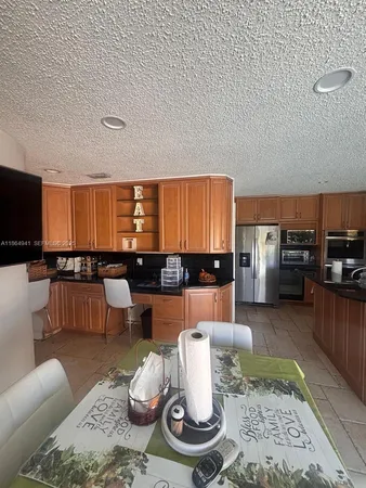 a living room with furniture kitchen view and a large window