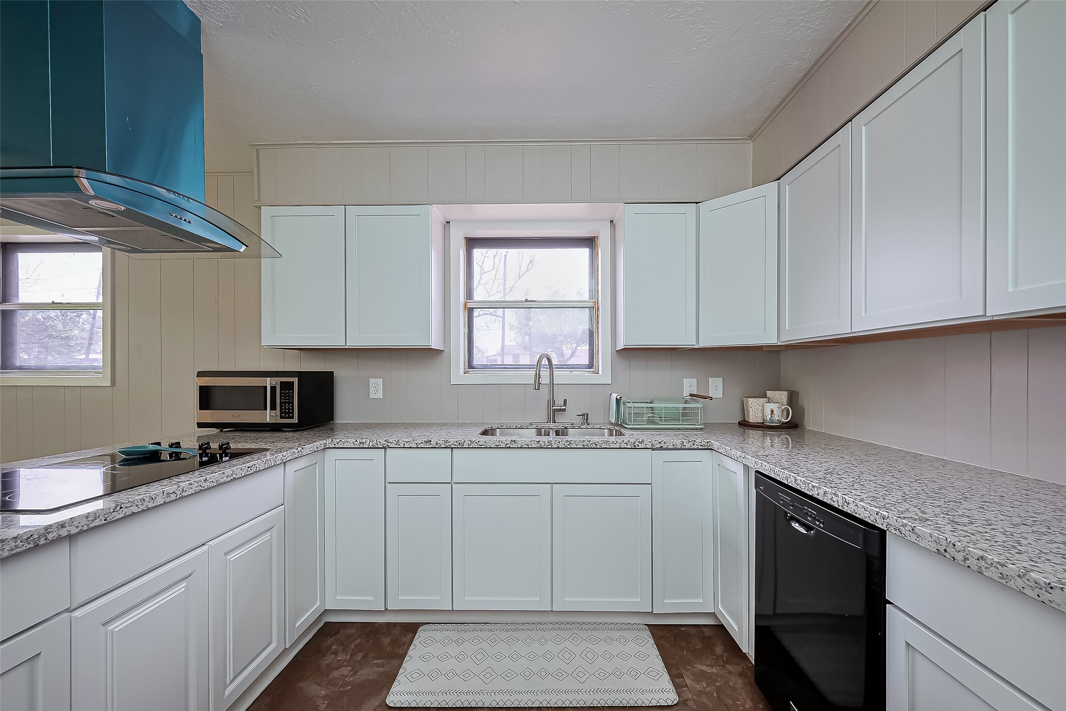 111 North 11th Street Highlands, TX 77562 - Photo 13 of 35 a kitchen with granite countertop white cabinets sink and stainless steel appliances