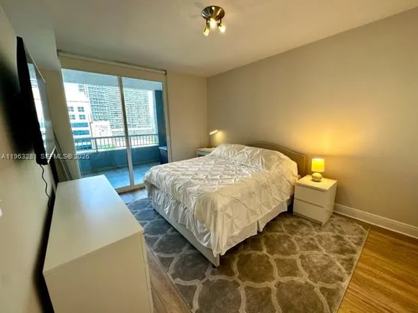 a bedroom with a bed and a flat tv screen on the table
