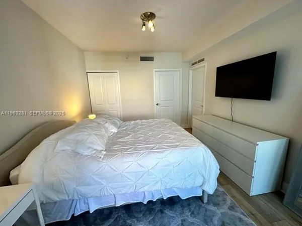 a bedroom with a bed and a flat screen tv