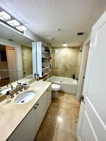 a bathroom with a granite countertop sink a mirror and a bathtub
