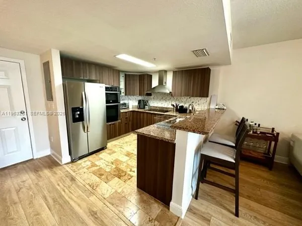a kitchen with refrigerator cabinets and wooden floor
