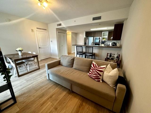170 Southeast 14th Street, Unit 1606 Miami, FL 33131 - Photo 6 of 24 a living room with furniture and a wooden floor