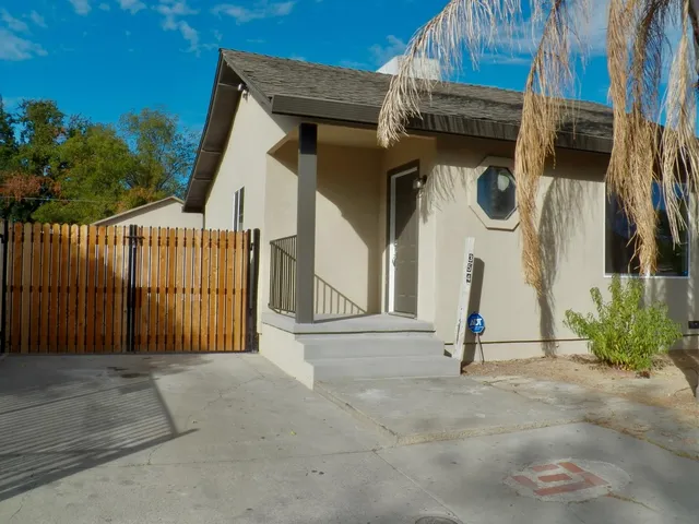 a view of a house with a wooden fence