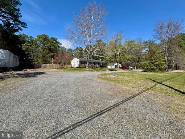 a view of a house with a yard and large tree