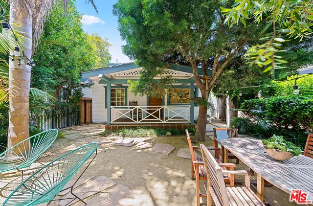 a view of a patio with table and chairs and potted plants with wooden floor and fence