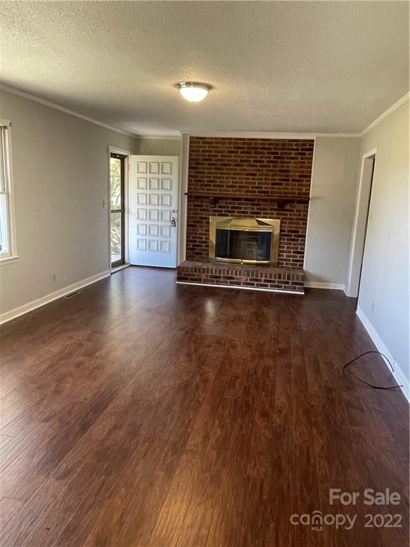2575 Briggs Road Salisbury, NC 28147 - Photo 2 of 13 an empty room with wooden floor and fireplace