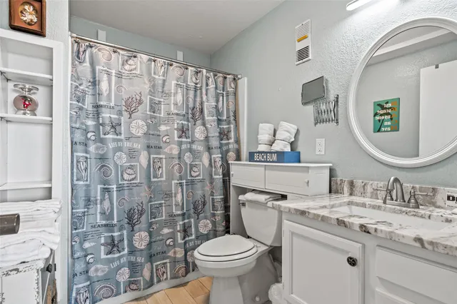 a bathroom with a granite countertop toilet sink and a mirror