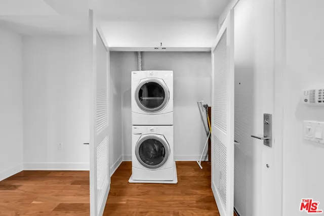 a kitchen with granite countertop stainless steel appliances a refrigerator cabinets and wooden floor