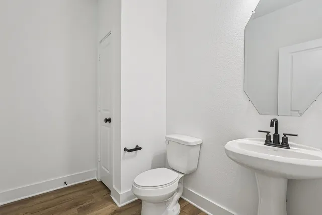 a bathroom with a toilet a sink and mirror