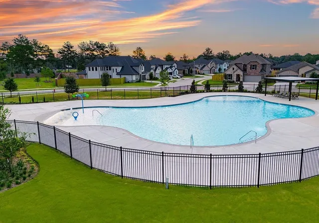 a view of a swimming pool with a yard and furniture
