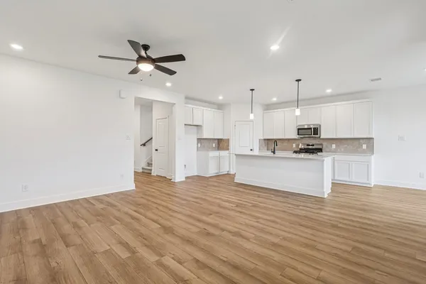 a view of kitchen with kitchen island wooden cabinets and refrigerator