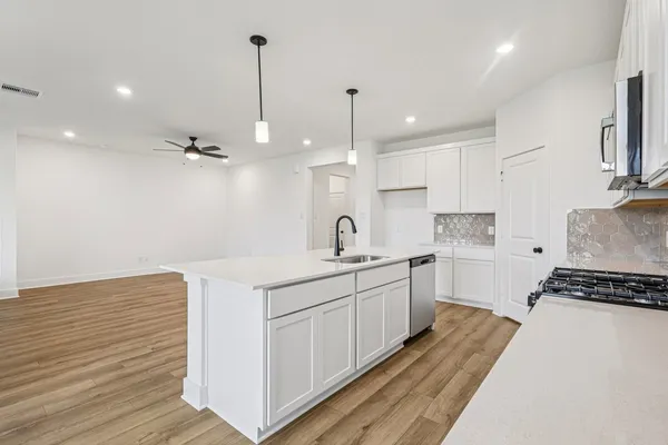 a kitchen with a sink stove and cabinets