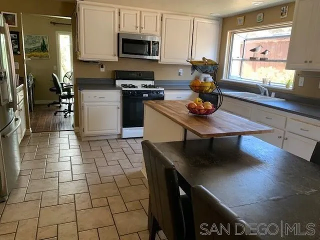 2710 Glasgow Drive Carlsbad, CA 92010 - Photo 2 of 10 a kitchen with stainless steel appliances a sink a stove cabinets and a dining table