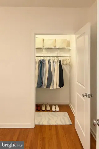 a view of walk in closet with clothes and shoes