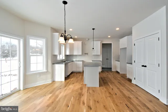 a large kitchen with white cabinets and stainless steel appliances