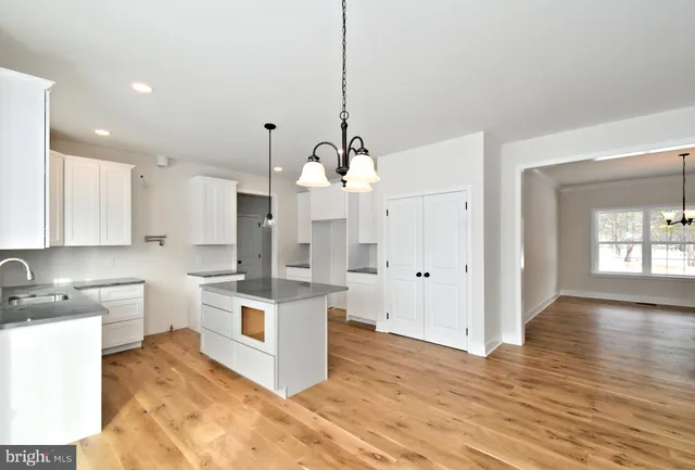 a kitchen with stainless steel appliances kitchen island granite countertop a sink stove and wooden floor
