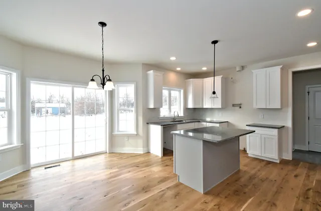a kitchen with stainless steel appliances granite countertop wooden floor sink and window