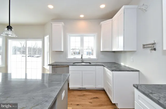 a kitchen with a sink a window and cabinets