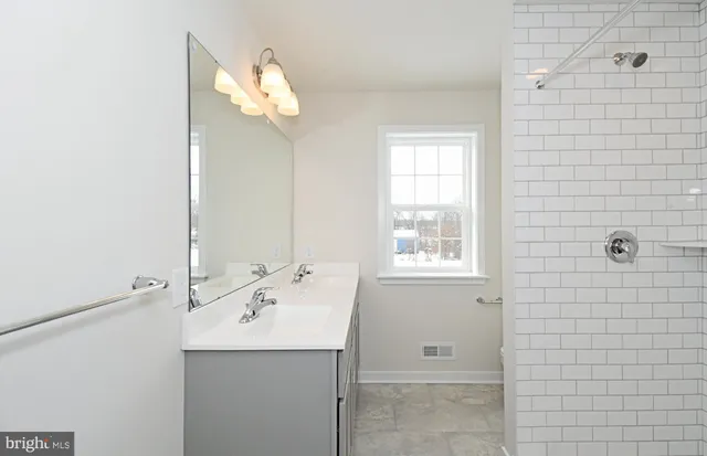 a bathroom with a sink a window and shower