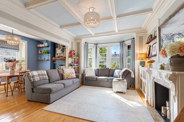 a living room with furniture a fireplace and a large window