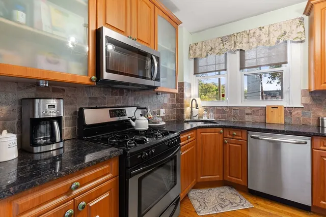a kitchen with stainless steel appliances granite countertop a stove a sink and a microwave