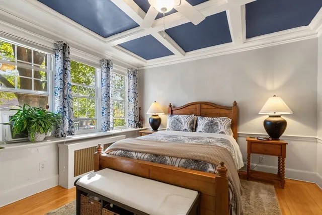 a bedroom with a bed a window and potted plant on the table
