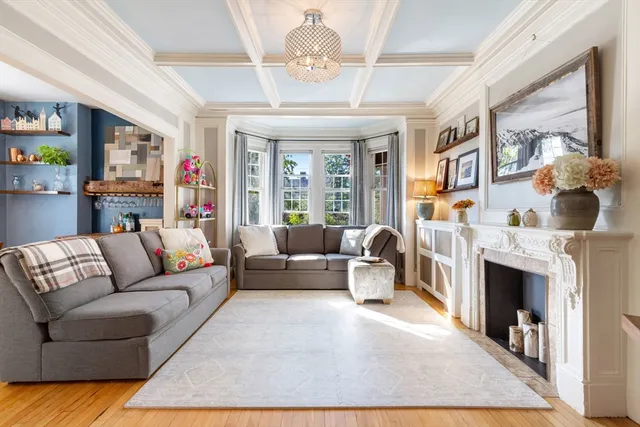 a living room with furniture a fireplace and a chandelier
