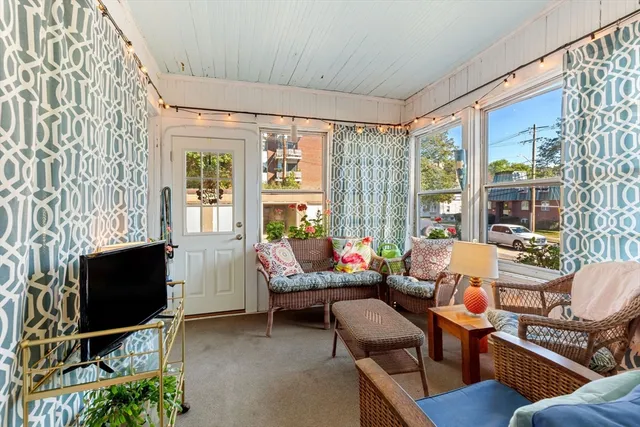 a living room with furniture a flat screen tv and a window