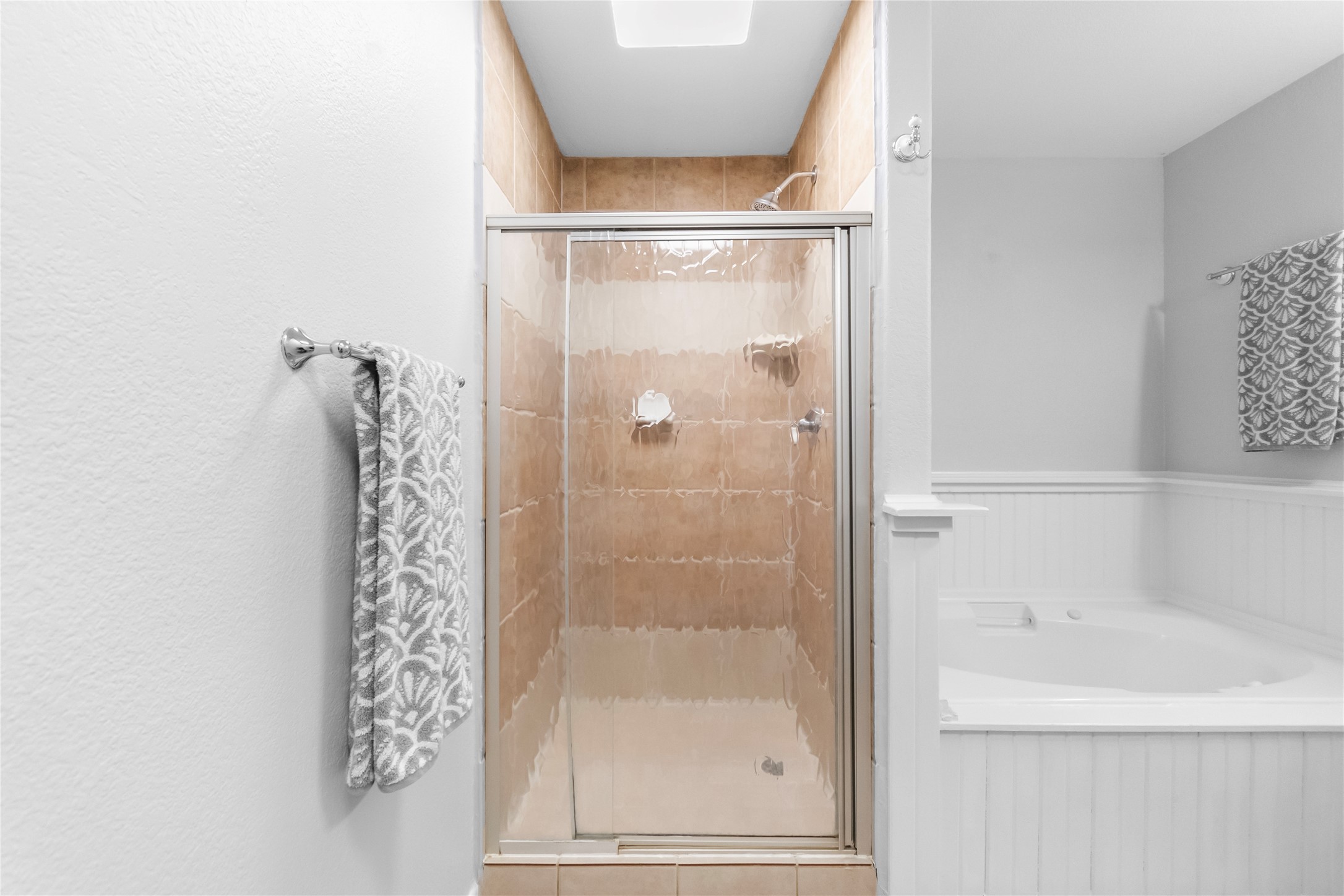210 Teeoff, Unit B Horseshoe Bay, TX 78657 - Photo 24 of 38 A well-appointed bath features a tiled shower stall and a relaxing corner tub.