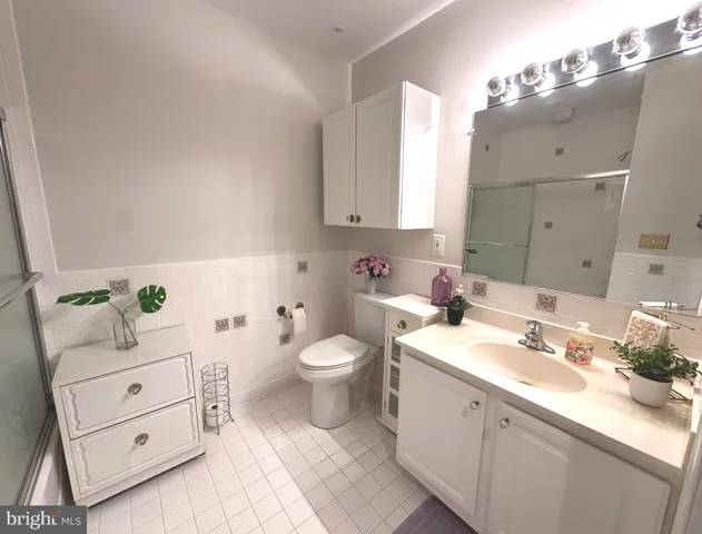 a bathroom with a granite countertop sink mirror and toilet
