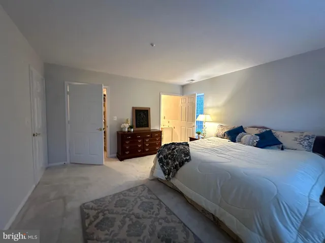 a large bedroom with a bed a television and dresser