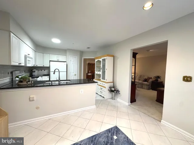 a large white kitchen with a large window and a counter space