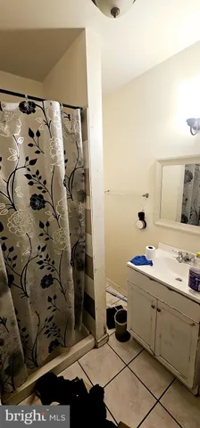 a bathroom with a sink and mirror with shower