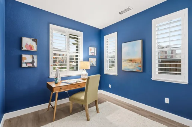 a view of a workspace with furniture and a window