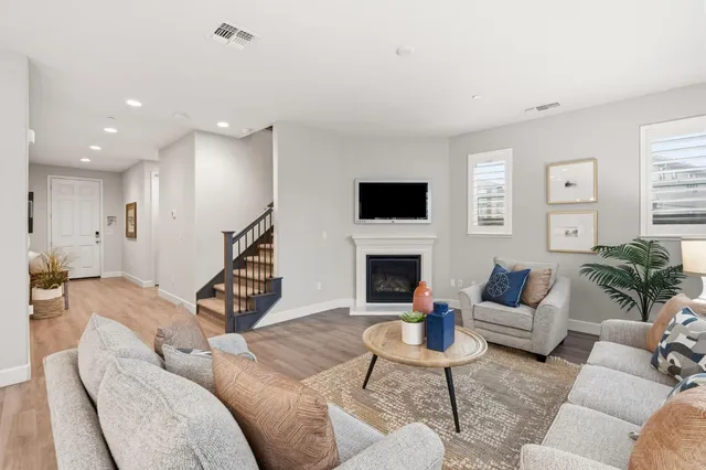 a living room with furniture a fireplace and a flat screen tv
