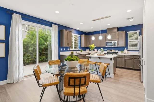 a dining room with kitchen island furniture a large window and kitchen view