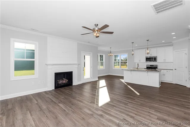 a kitchen with kitchen island granite countertop a sink stainless steel appliances and white cabinets