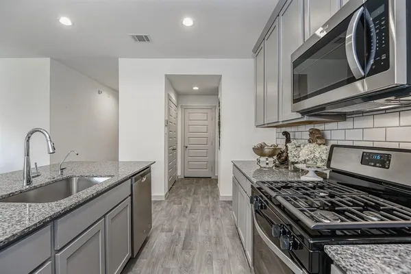 a kitchen with granite countertop a stove and a sink