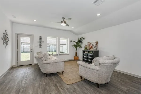 a living room with furniture and wooden floor