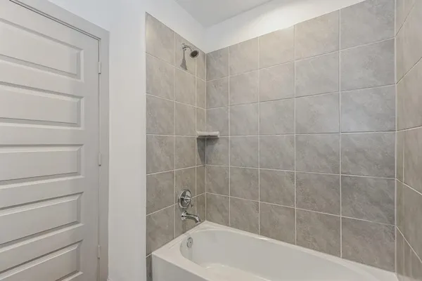 a white bath tub sitting next to a white wall