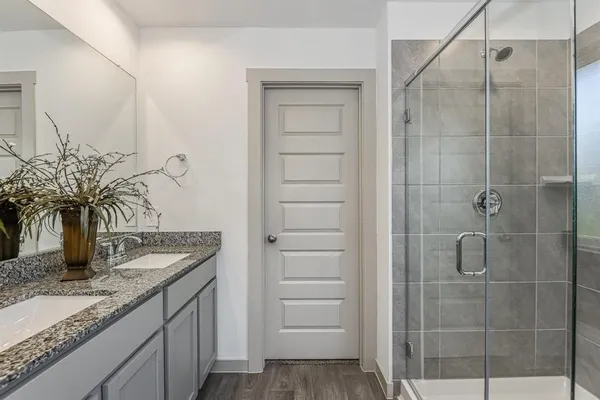 a bathroom with a granite countertop sink a mirror and shower